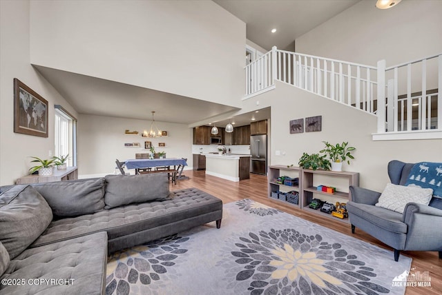 2945 Morgan Loop, Anchorage, AK 99516 - living area with light wood-style floors, a chandelier, a high ceiling, stairs, and recessed lighting