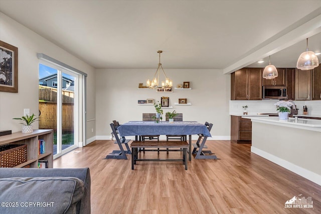 2945 Morgan Loop, Anchorage, AK 99516 - dining area with a chandelier, light wood finished floors, and baseboards