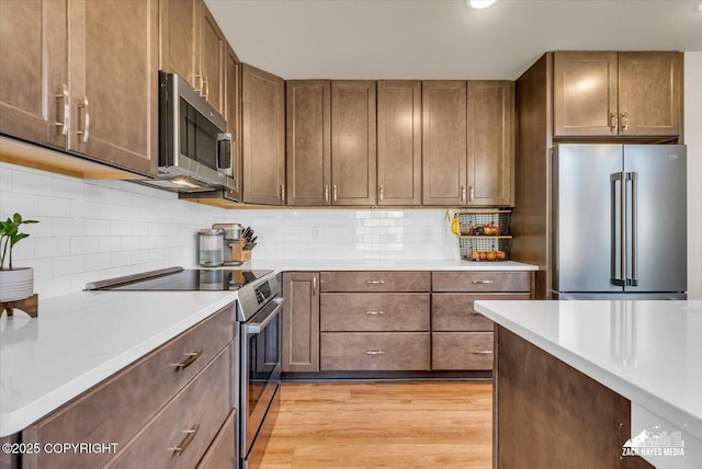 2945 Morgan Loop, Anchorage, AK 99516 - kitchen with appliances with stainless steel finishes, light wood-type flooring, light countertops, backsplash, and recessed lighting
