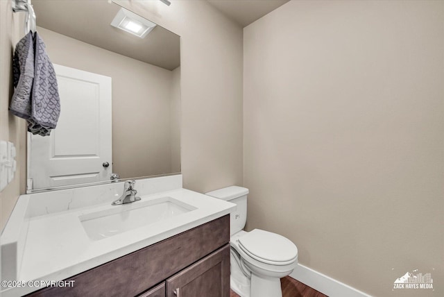 2945 Morgan Loop, Anchorage, AK 99516 - half bath featuring toilet, vanity, baseboards, and wood finished floors
