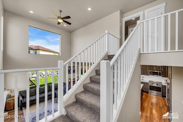2945 Morgan Loop, Anchorage, AK 99516 - staircase featuring a ceiling fan, recessed lighting, a towering ceiling, and wood finished floors