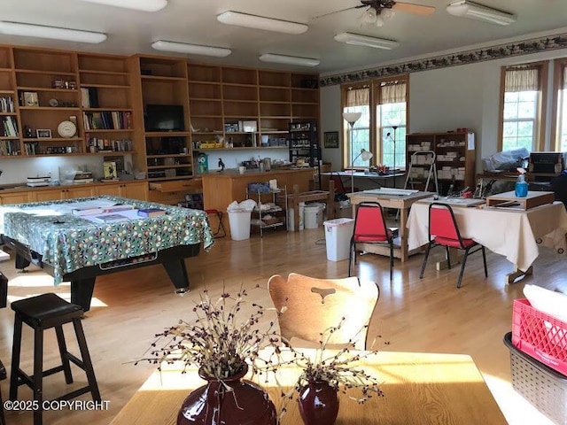 game room with light wood-style floors, ceiling fan, and a desk