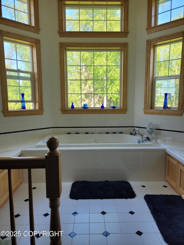 bathroom with healthy amount of natural light, a garden tub, tile patterned floors, and radiator heating unit