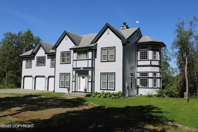 view of front of house featuring an attached garage, a chimney, concrete driveway, a front yard, and roof with shingles