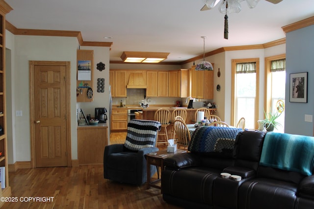 living room featuring crown molding, wood finished floors, and a ceiling fan