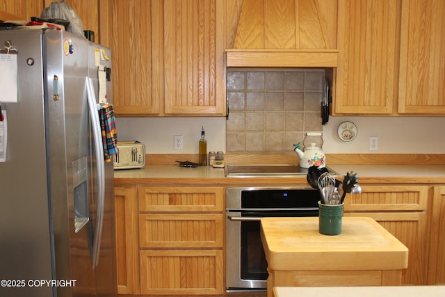 kitchen featuring stainless steel appliances, wood counters, and backsplash