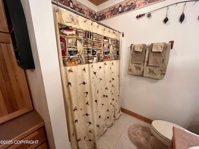 bathroom featuring toilet, a shower with shower curtain, tile patterned floors, and baseboards