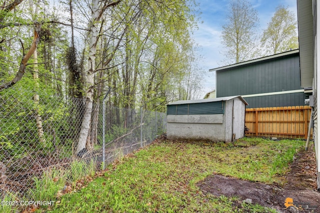 fenced backyard featuring a storage unit and an outdoor structure
