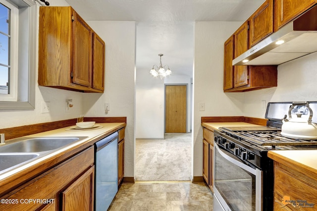 kitchen featuring appliances with stainless steel finishes, under cabinet range hood, brown cabinetry, and a chandelier