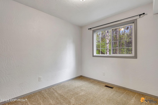 empty room featuring carpet floors and baseboards