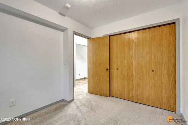 unfurnished bedroom featuring carpet, a closet, and baseboards