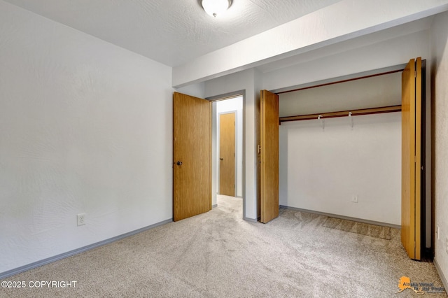 unfurnished bedroom featuring carpet floors, a closet, and baseboards