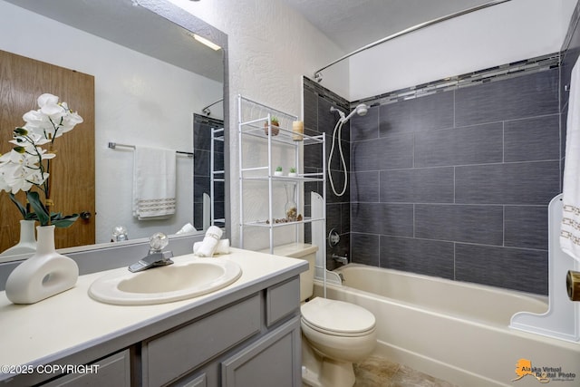 bathroom with vanity, washtub / shower combination, toilet, tile patterned floors, and a textured wall