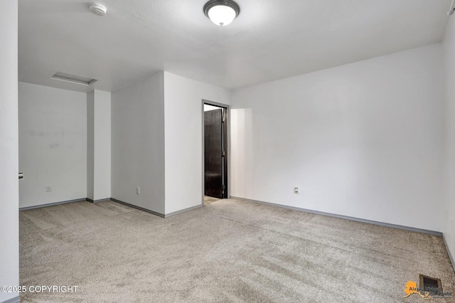 spare room with a smoke detector, carpet floors, and baseboards
