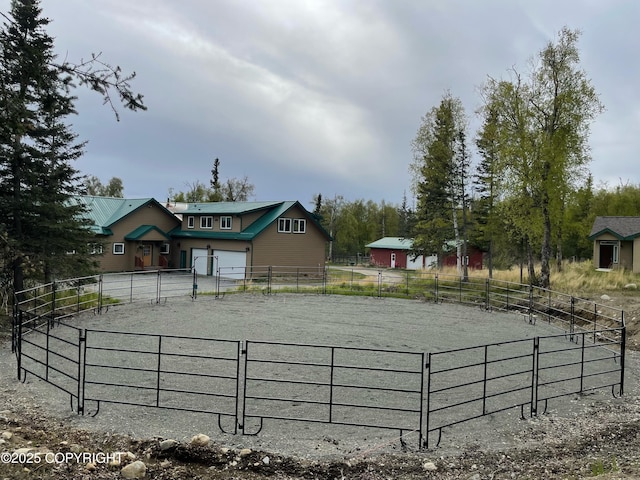 exterior space featuring asphalt driveway and an enclosed horse arena
