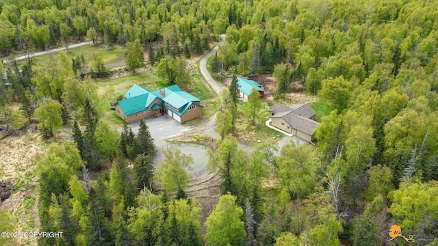 aerial view of property and surrounding area with a heavily wooded area