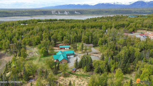 aerial view of property and surrounding area with a heavily wooded area and a mountainous background