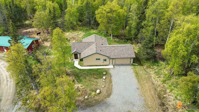 aerial view of property and surrounding area with a heavily wooded area