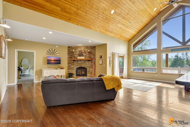 living room featuring dark wood-type flooring, a fireplace, high vaulted ceiling, baseboards, and recessed lighting