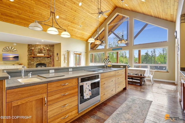kitchen with a sink, oven, wooden ceiling, stovetop with downdraft, and high vaulted ceiling