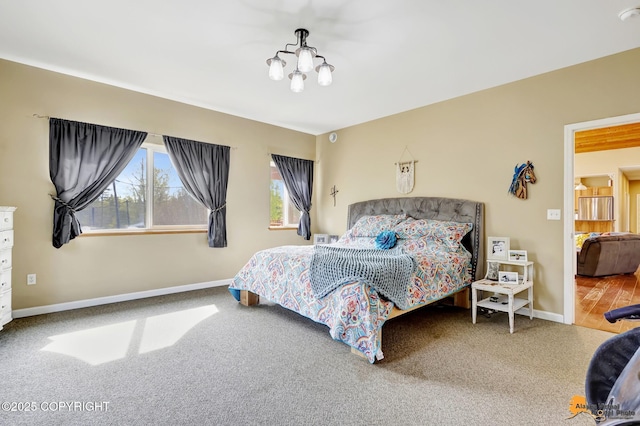 carpeted bedroom with a chandelier and baseboards