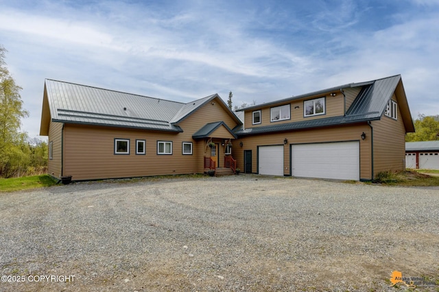 rustic home featuring gravel driveway and metal roof