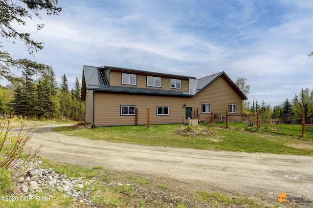 view of side of home featuring driveway and a lawn