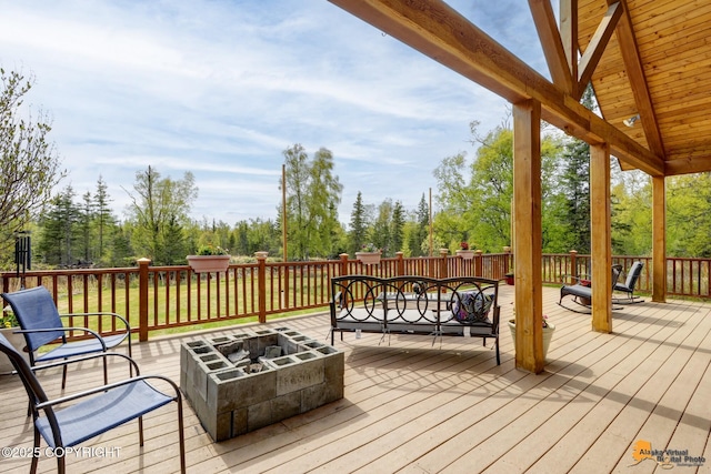 wooden terrace featuring an outdoor living space with a fire pit