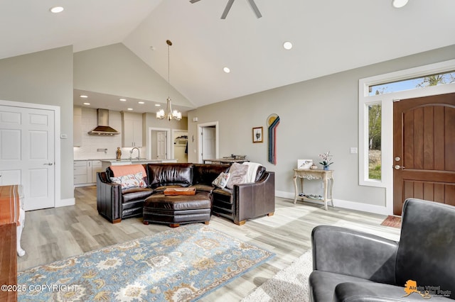 living area with a chandelier, high vaulted ceiling, light wood-style floors, recessed lighting, and ceiling fan