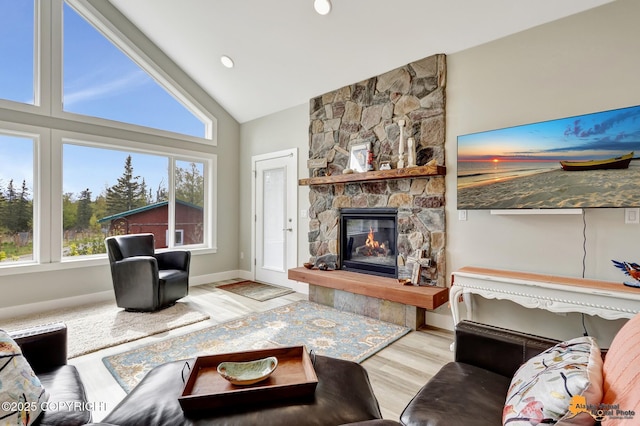 living room featuring lofted ceiling, wood finished floors, a fireplace, and baseboards