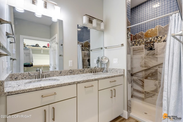full bath featuring a stall shower, double vanity, and a spacious closet