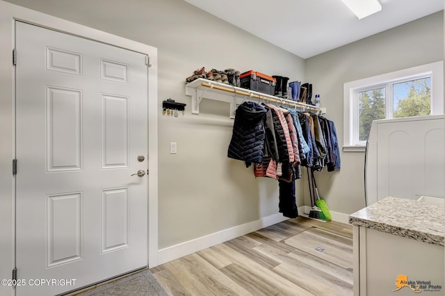 mudroom featuring light wood finished floors and baseboards