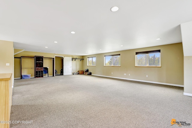 unfurnished living room with carpet flooring, recessed lighting, and baseboards