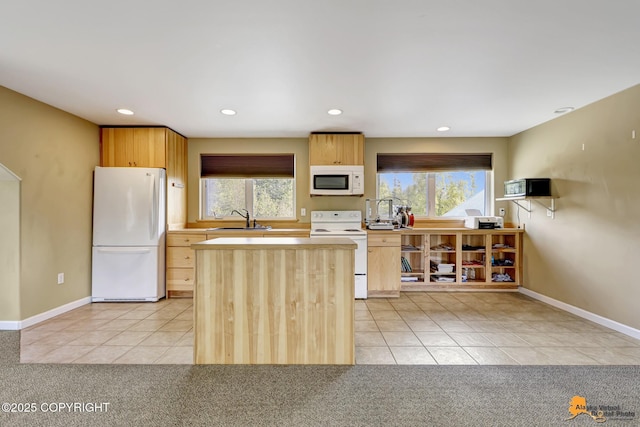 kitchen with white appliances, light tile patterned flooring, a sink, light brown cabinetry, and recessed lighting