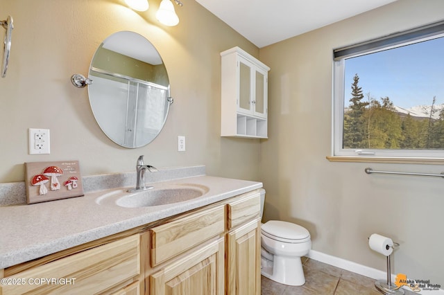 bathroom featuring tile patterned flooring, toilet, vanity, and a shower