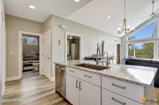 kitchen featuring stainless steel dishwasher, a ceiling fan, a sink, open floor plan, and recessed lighting