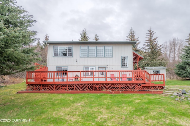 rear view of property featuring a lawn and a deck