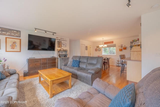 living area featuring track lighting, a chandelier, and wood finished floors