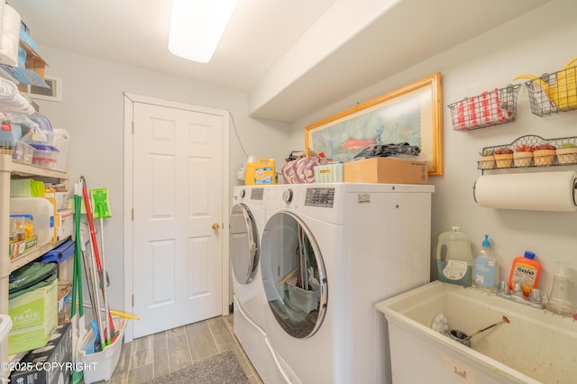 laundry room with washer and dryer and light wood-style floors
