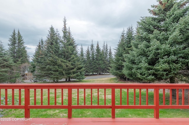 wooden deck featuring a lawn
