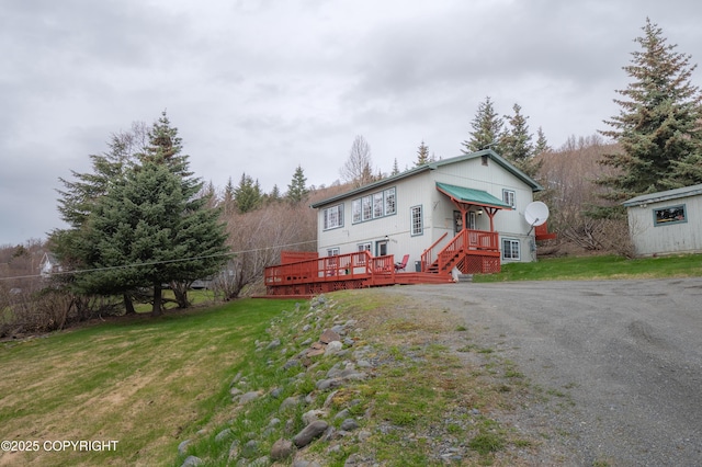 split foyer home with a wooden deck and a front yard