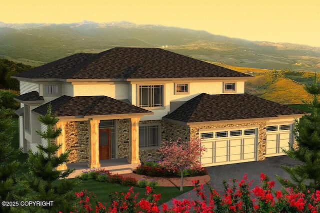 view of front of home featuring stone siding, stucco siding, a garage, asphalt driveway, and a mountain view
