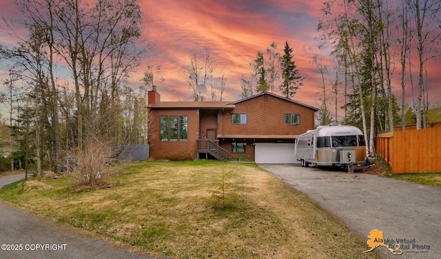 view of front of home with a chimney, asphalt driveway, and an attached garage
