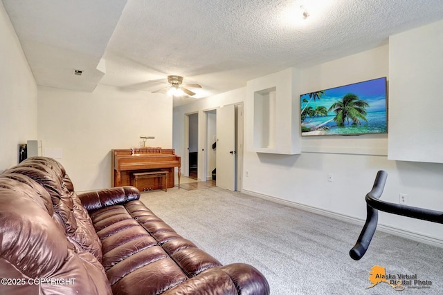 carpeted living room featuring a ceiling fan and a textured ceiling