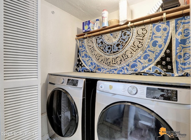 clothes washing area with a textured ceiling and washer and dryer
