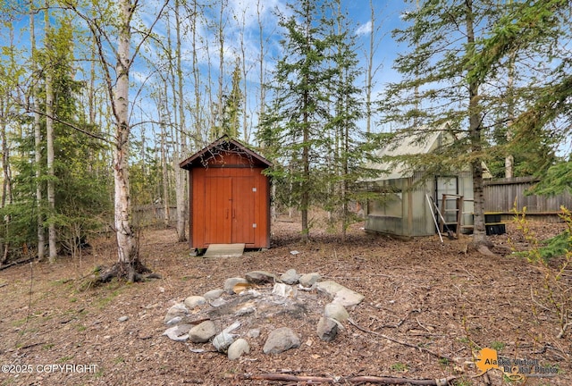 view of yard with an outdoor structure, a storage unit, and fence