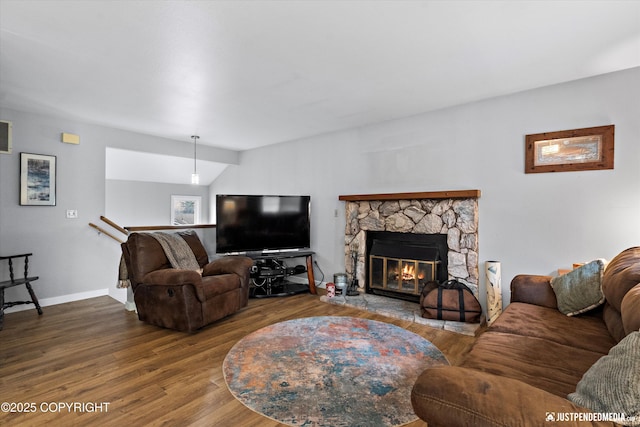 living area featuring wood finished floors, a fireplace, and baseboards