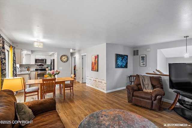 living area with light wood-type flooring and baseboards