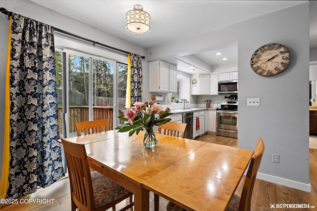 dining area featuring light wood-type flooring, baseboards, and recessed lighting