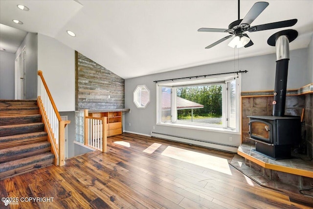 4035 S Tustin Dr, Palmer, AK 99645 - unfurnished living room with a baseboard heating unit, vaulted ceiling, wood finished floors, a ceiling fan, and a wood stove